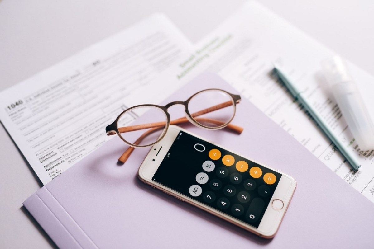 Investissement sans risque – Dossier de financement pour obtenir un prêt avec une paire de lunettes et un smartphone au premier plan