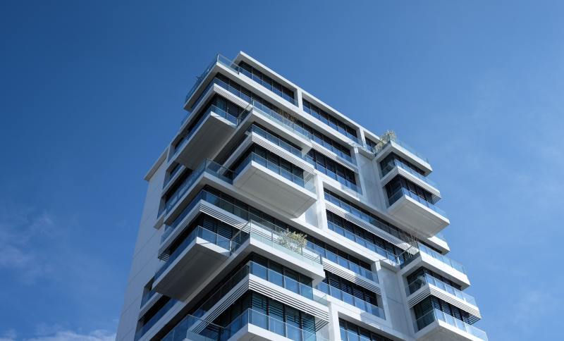 Mal logement en France – Une résidence moderne à la façade blanche sous un ciel bleu