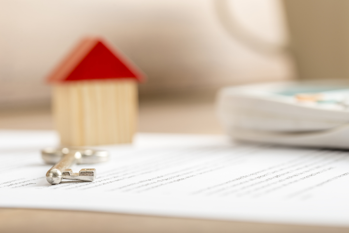  Loi Pinel garantie des loyers – Une maison miniature en bois et une clé sur un contrat de location 